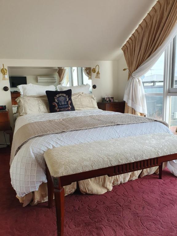 莫宁顿Mornington Guest House的一间卧室设有一张大床和一个窗户。