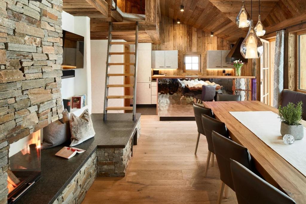 弗拉绍Komfortables Ferienhaus in Flachau mit Garten, Grill und Sauna und Panoramablick的一间厨房和带石墙的用餐室