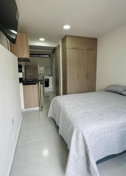 弗洛伦西亚Loft con aire acondicionado的一间带白色床的卧室和一间厨房
