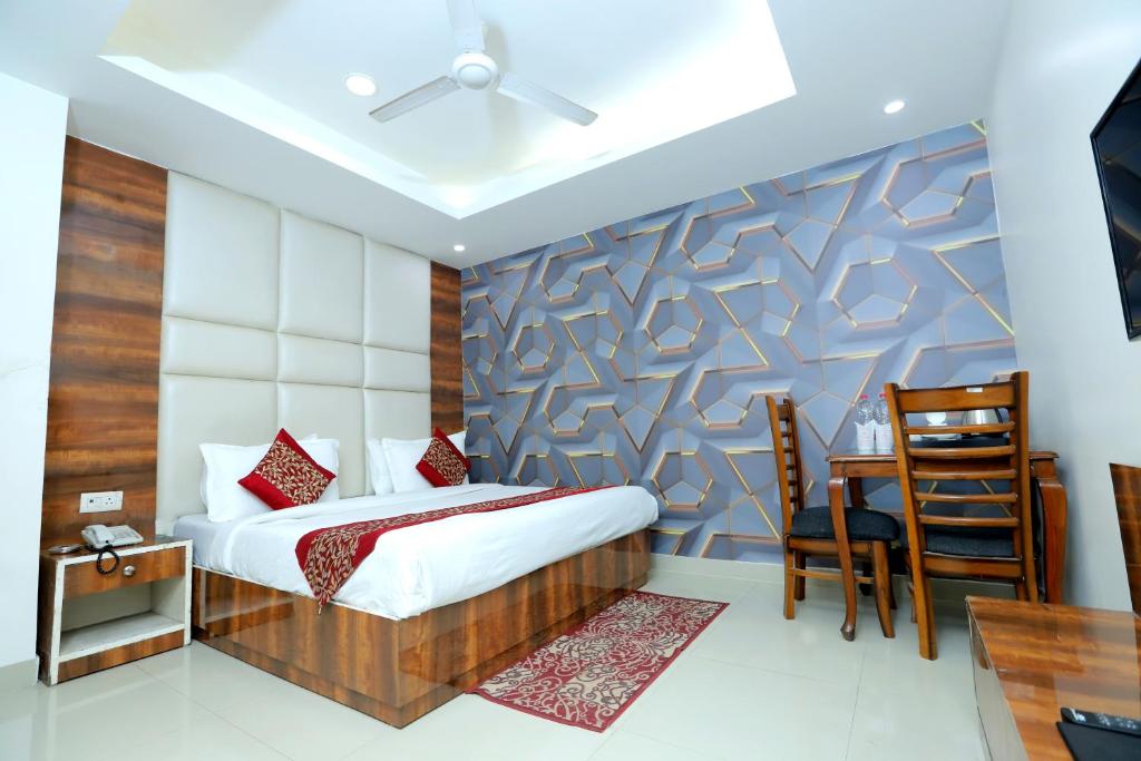新德里Hotel Mars Meg at Delhi Airport的一间卧室配有一张床、一张桌子和一把椅子