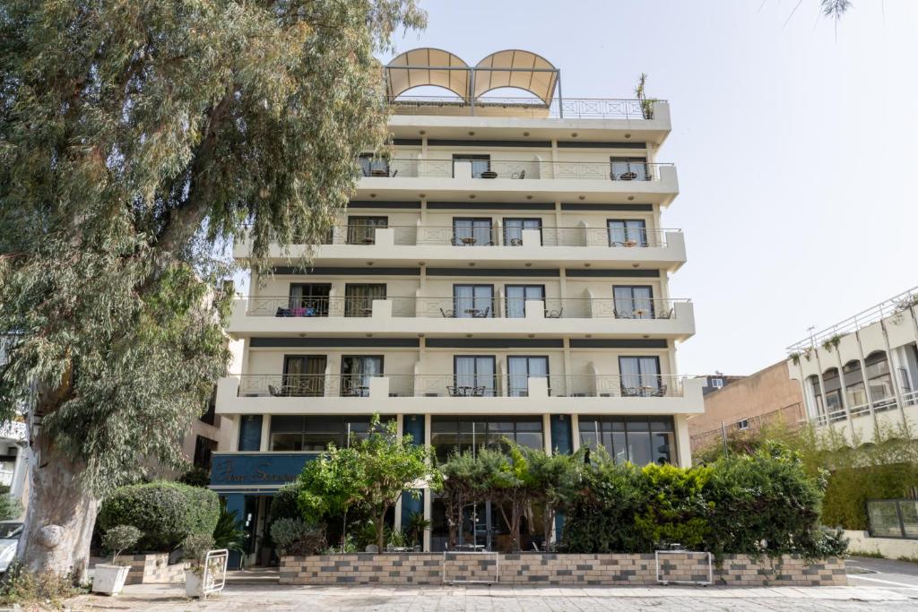 雅典四季酒店的公寓大楼设有阳台和一棵树