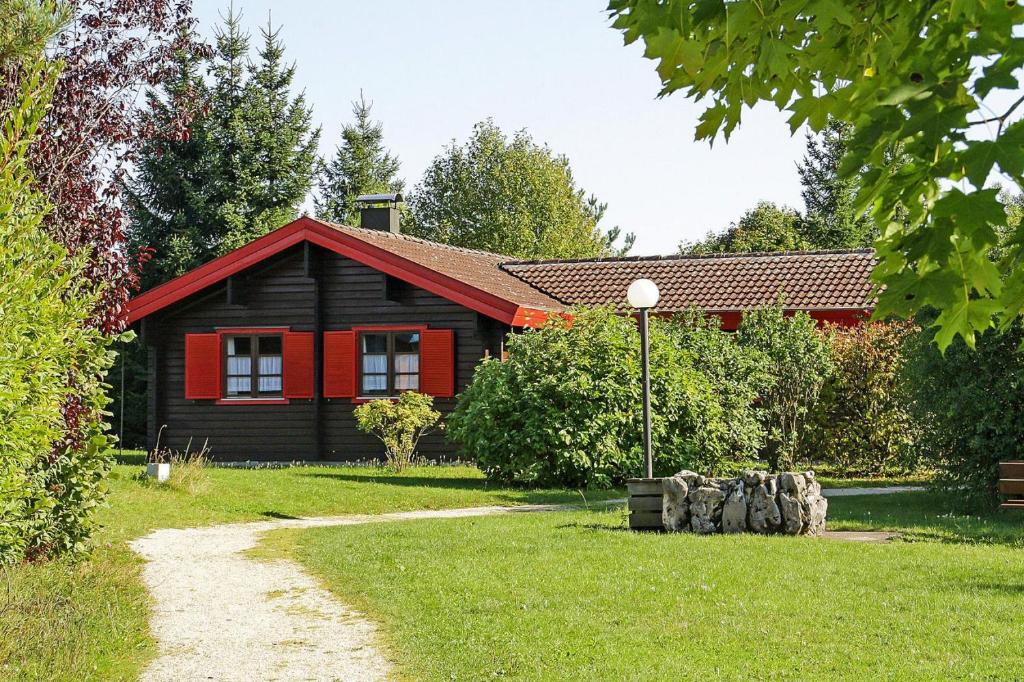 HayingenHoliday homes Lauterd rfle Hayingen的一座红黑房子,有草地庭院