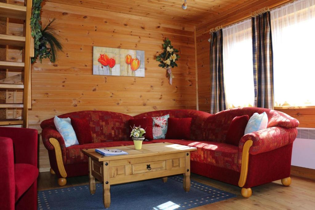 巴特萨克萨Blockhouse in the Fuchsbau Bad Sachsa的客厅配有两张红色的沙发和一张桌子