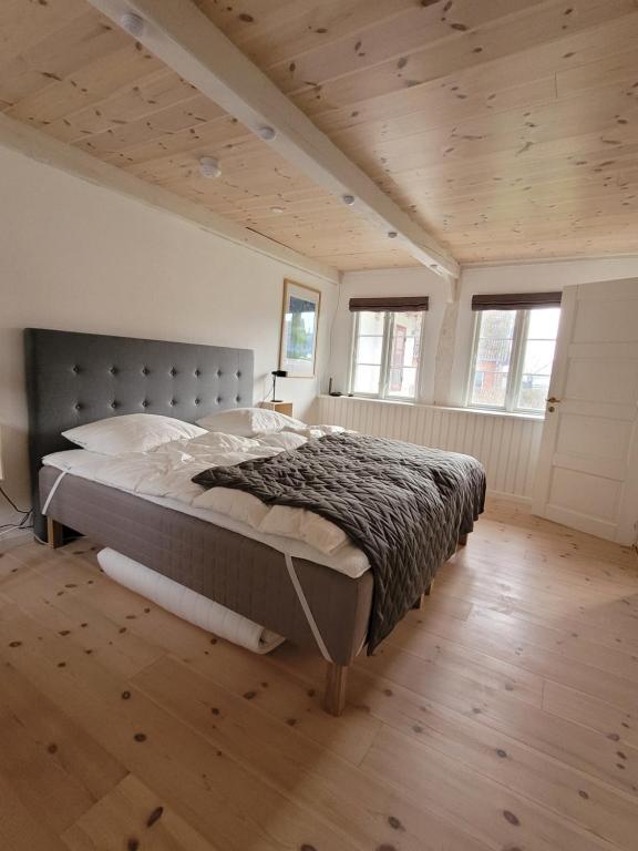 NyordRagnhilds Gård, Hostel的铺有木地板的客房设有一间带大床的卧室