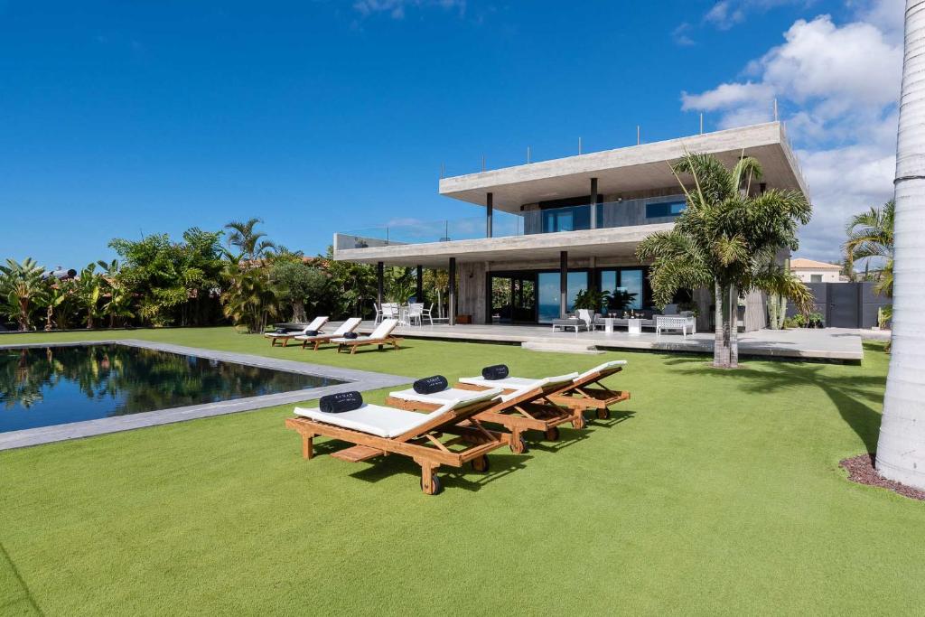 帕莱索海滩Karat Atelier de la vega的一座房子,前面设有游泳池和野餐桌
