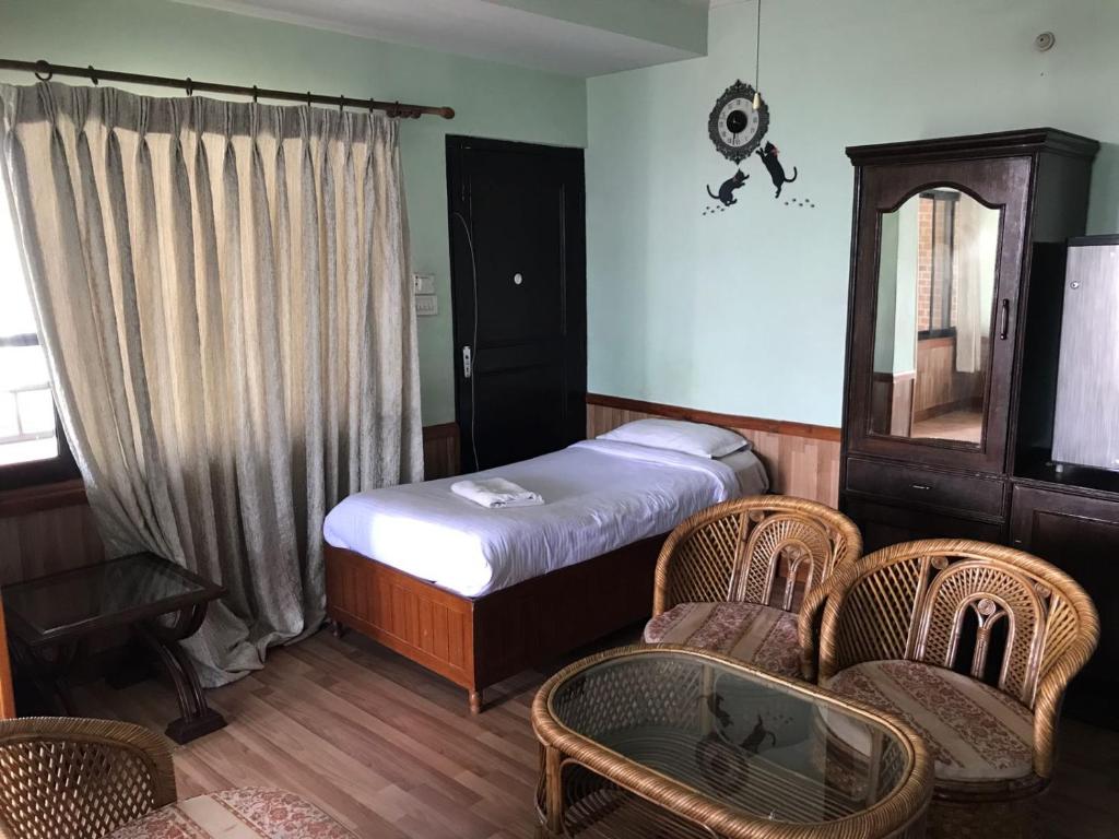 加德满都Hotel Mandala的一间卧室配有床、椅子和窗户