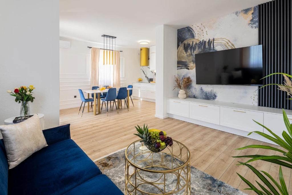 特罗吉尔VIPo Seget Apartments的客厅配有蓝色的沙发和电视