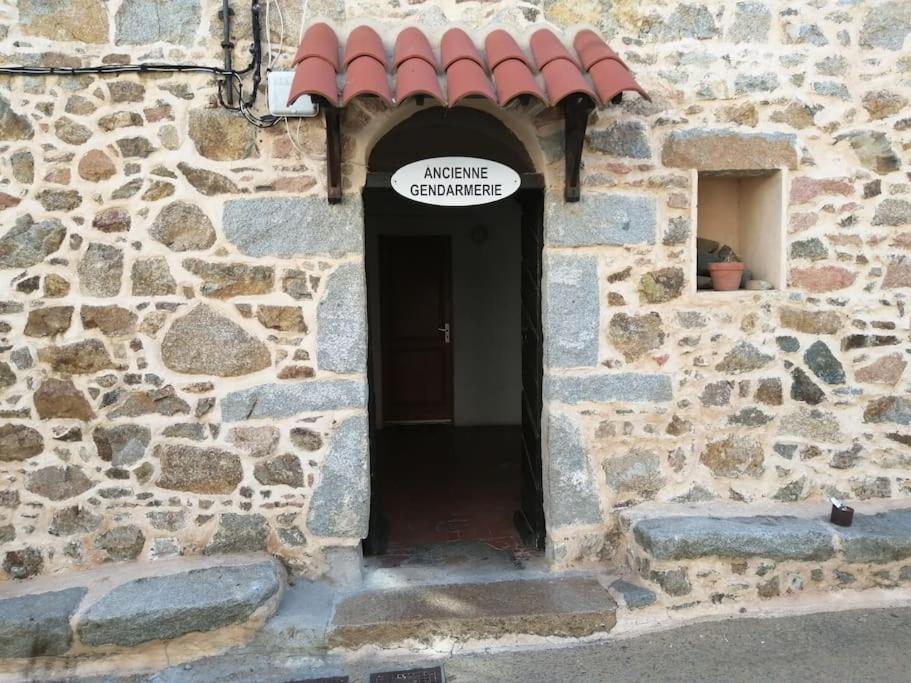 皮亚纳Ravissant appartement au cœur de Piana的通往石头建筑的门道,上面有标志
