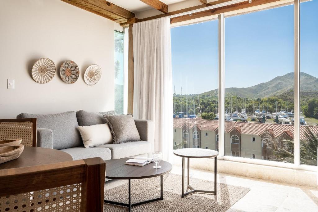GurapitoCofresi Hills Residence的带沙发和大窗户的客厅