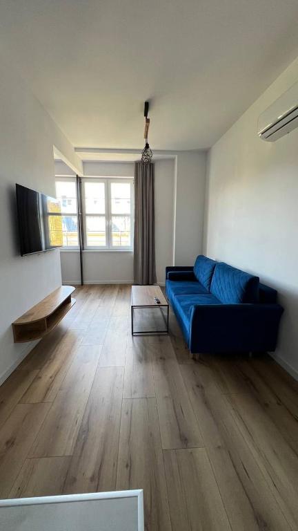 别尔斯克-比亚拉CityCenterApartments/M32/8B的客厅设有蓝色的沙发和木地板
