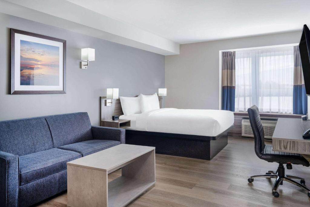 卡纳塔Microtel Inn & Suites by Wyndham Kanata Ottawa West的酒店客房,配有床和沙发