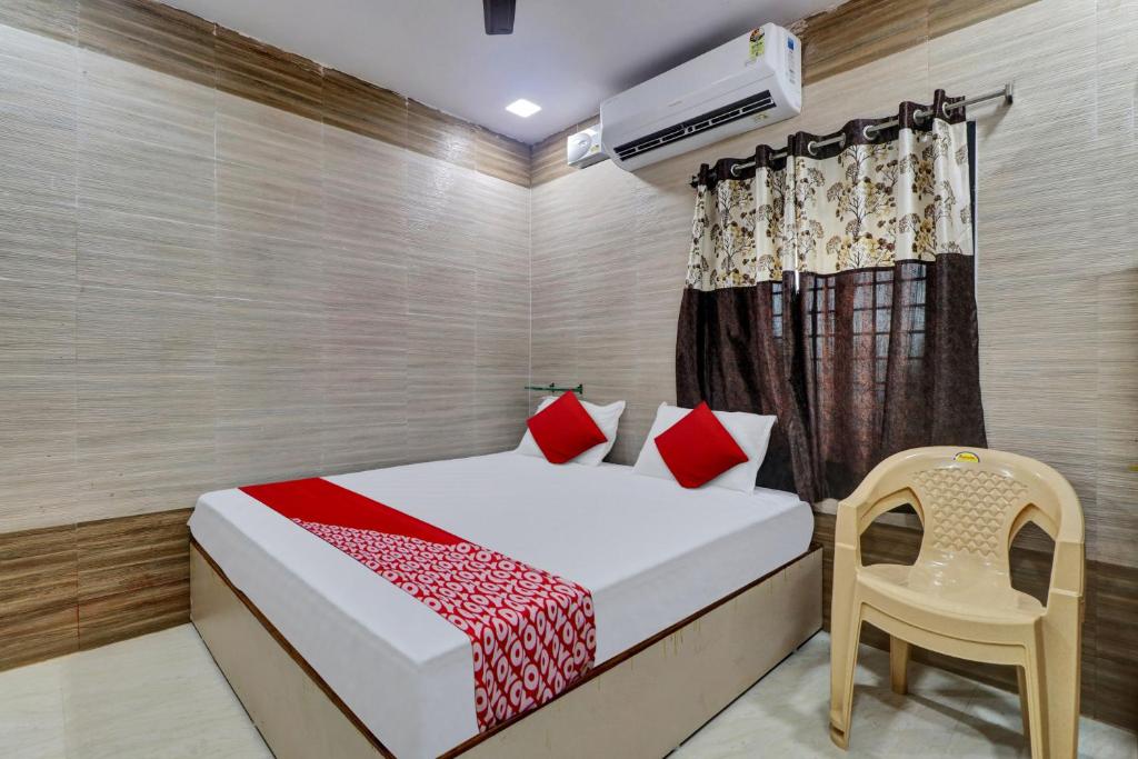 拉加蒙德里Hotel Vallabha Residency的一间卧室配有一张床和一把椅子