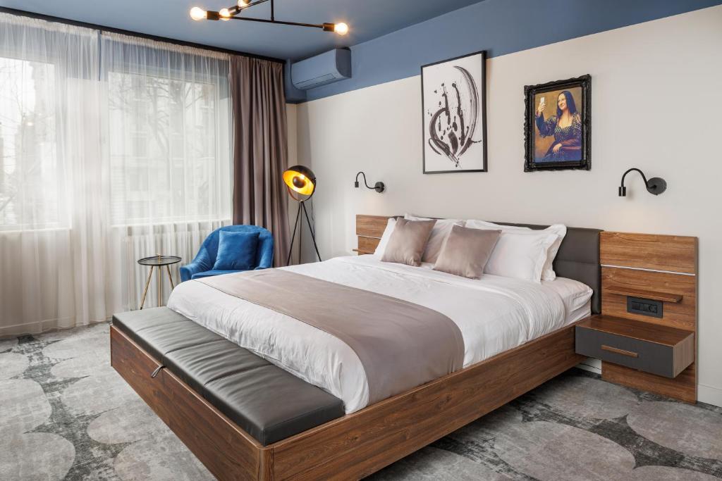 布加勒斯特布加勒斯特舒适套房酒店的一间卧室设有一张大床和蓝色的墙壁
