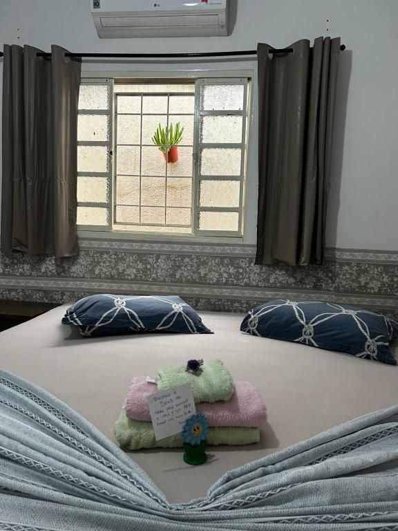 大坎普Pousada e Hotel Italian Garden House的一张带毛巾的床和窗户