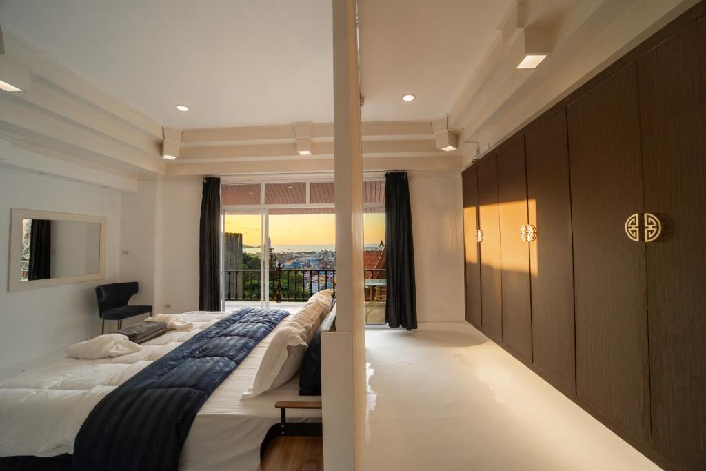 芭东海滩私人泳池 芭东海景 绝美落日 四卧别墅的一间卧室设有一张大床和一个窗户。