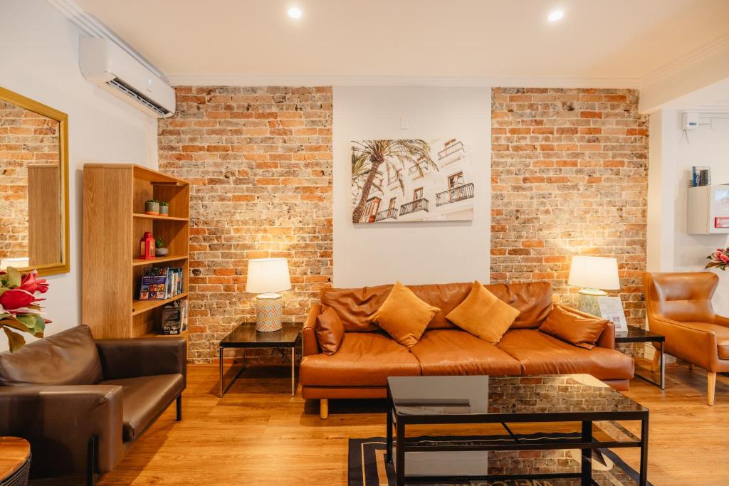悉尼Newtown Cozy Stays的带沙发和砖墙的客厅