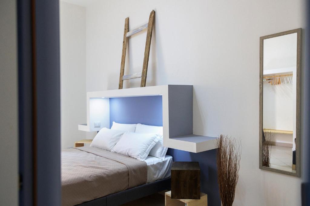 锡拉库扎Elsa d'Ortigia的一间卧室配有一张带蓝色床头板和镜子的床