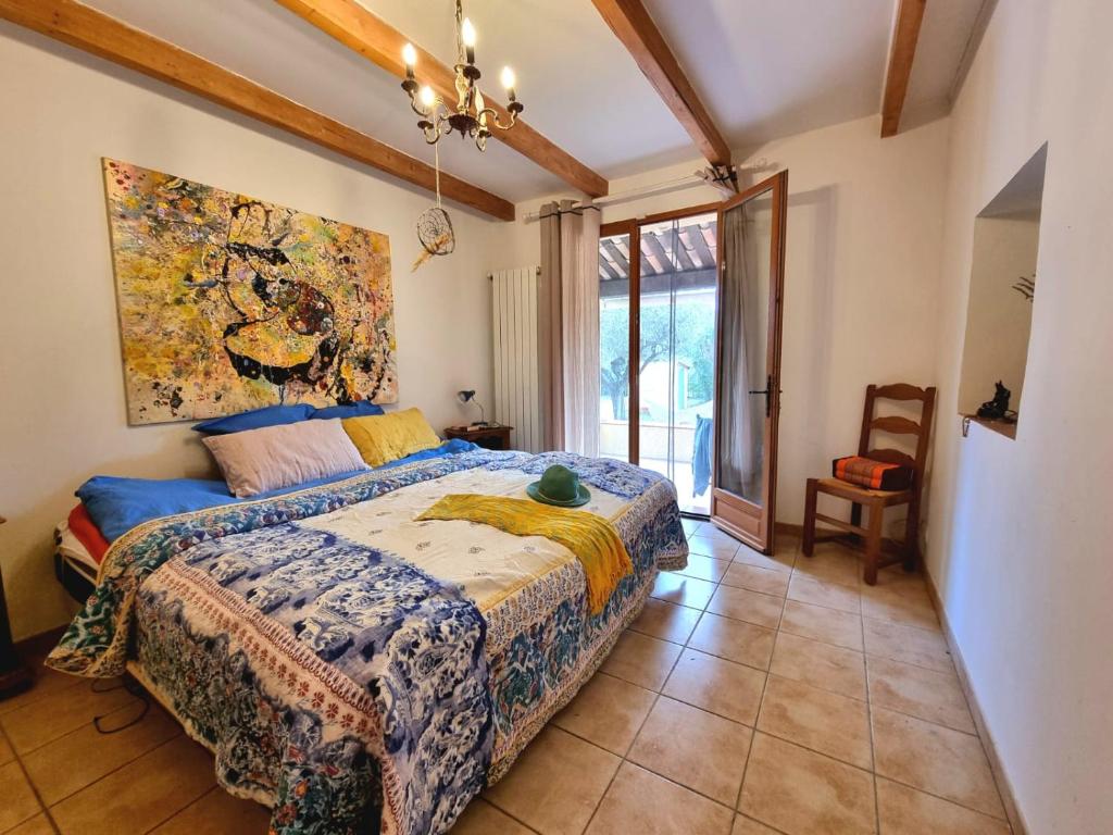 洛尔格La Maison de Blu的卧室配有一张床,墙上挂有绘画作品