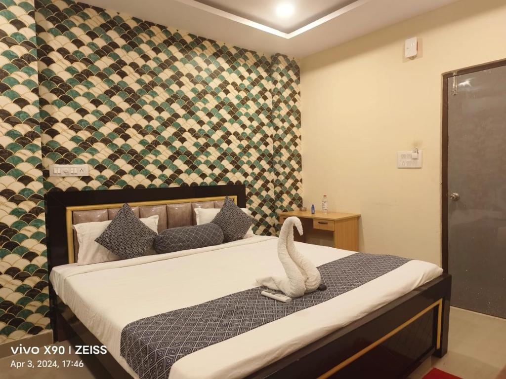 商沙巴HOTEL SANTHOSH DHABA SUITES-NEAR AIRPORT Zone的一间卧室配有一张带天鹅的床