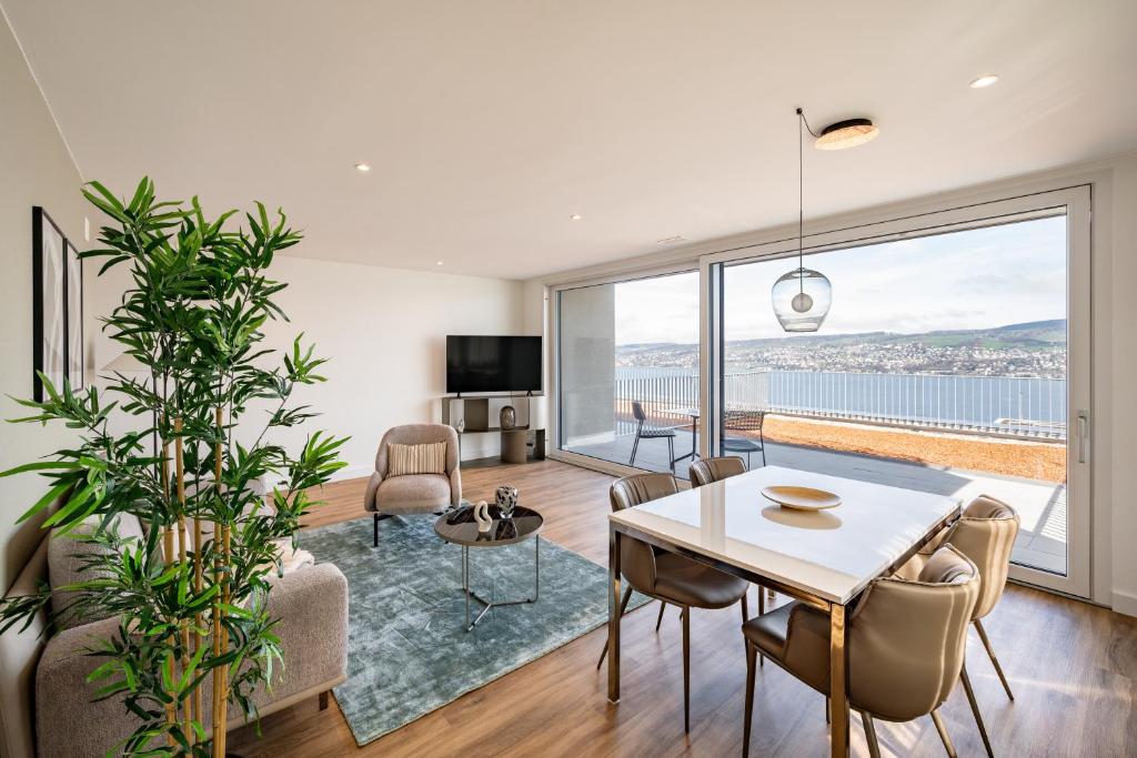 豪尔根aestate living lakeview in Horgen Zürich Zug Pfäffikon的客厅配有桌椅和大窗户