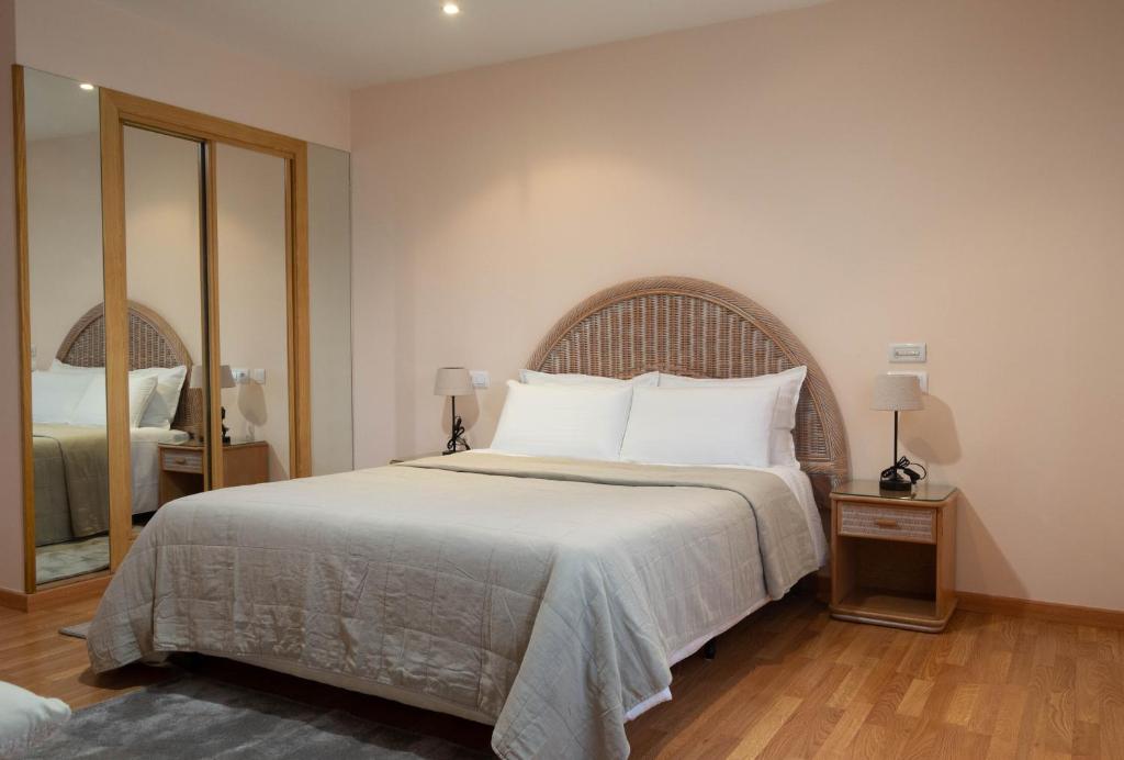 卢戈Motel Bambú的一间卧室配有一张大床和镜子