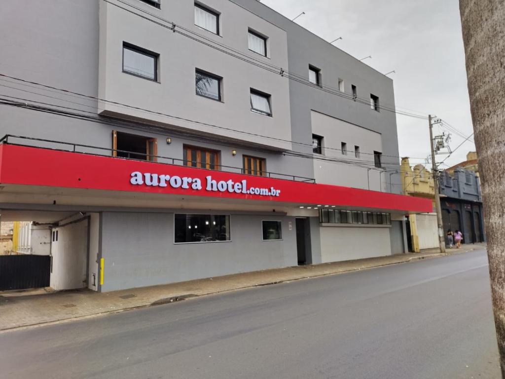 里贝朗普雷托Aurora Hotel的一面有红色标志的建筑物