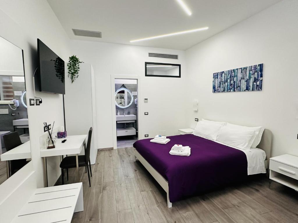 罗马San Saba Street Apartment 48的一间卧室配有一张紫色的床和一张书桌
