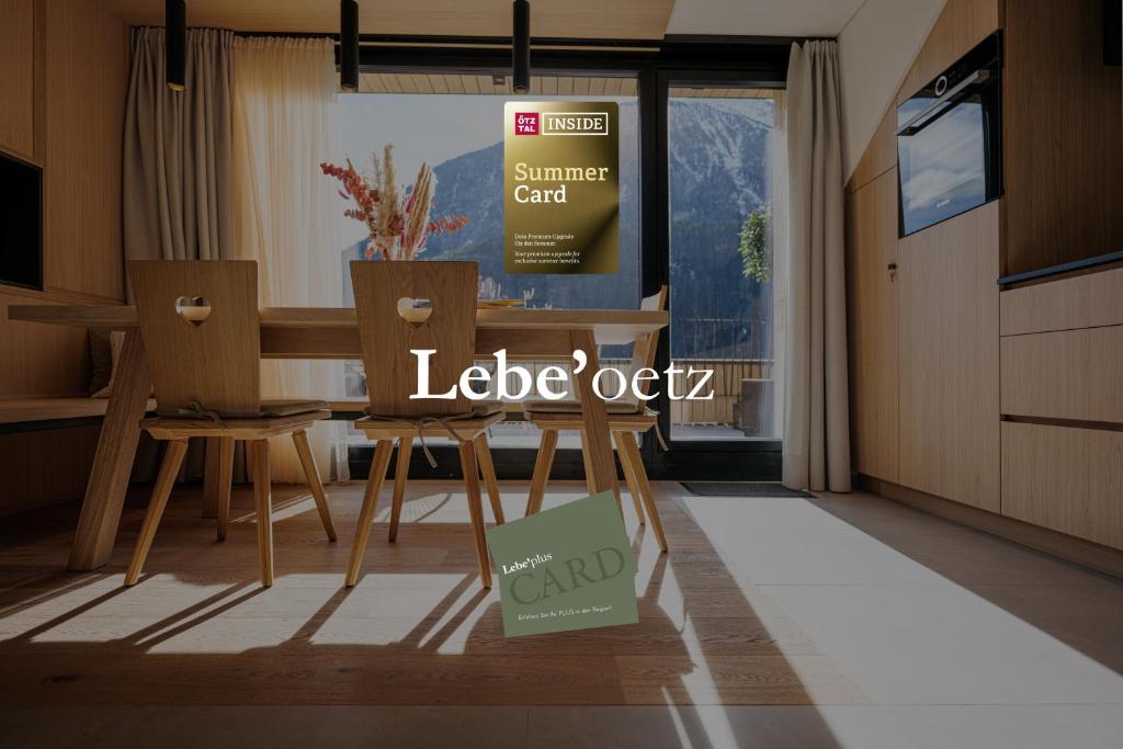 厄茨Lebe`oetz - Das Ferienapartmenthaus im Zentrum von Oetz的厨房配有桌椅和阅读花环橡木的标志