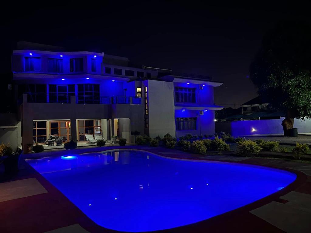 MatolaCASA AZUL ACCOMMODATION的夜晚在房子前面的一个蓝色泳池