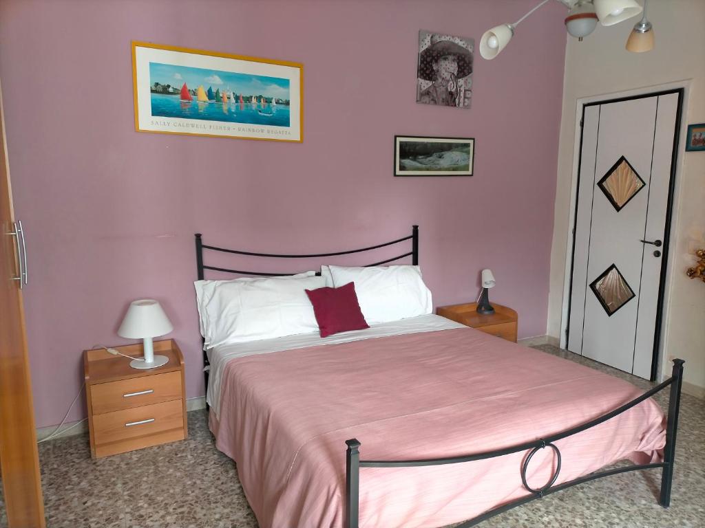 锡拉库扎Sleep In Sicily的一间卧室配有一张粉红色墙壁的床