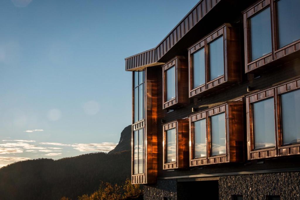 海姆瑟达尔Skarsnuten Mountian SPA&Resort的一座带窗户的建筑,背景是群山