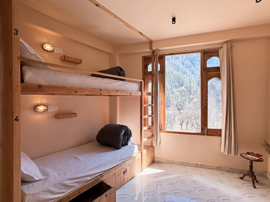 卡索尔Grham Hostel Kasol, Katagla的客房设有两张双层床和一扇窗户。