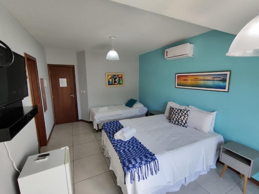 阿拉亚尔-杜卡布Pousada Estalagem dos Corais da Prainha的一间酒店客房,设有两张床和电视