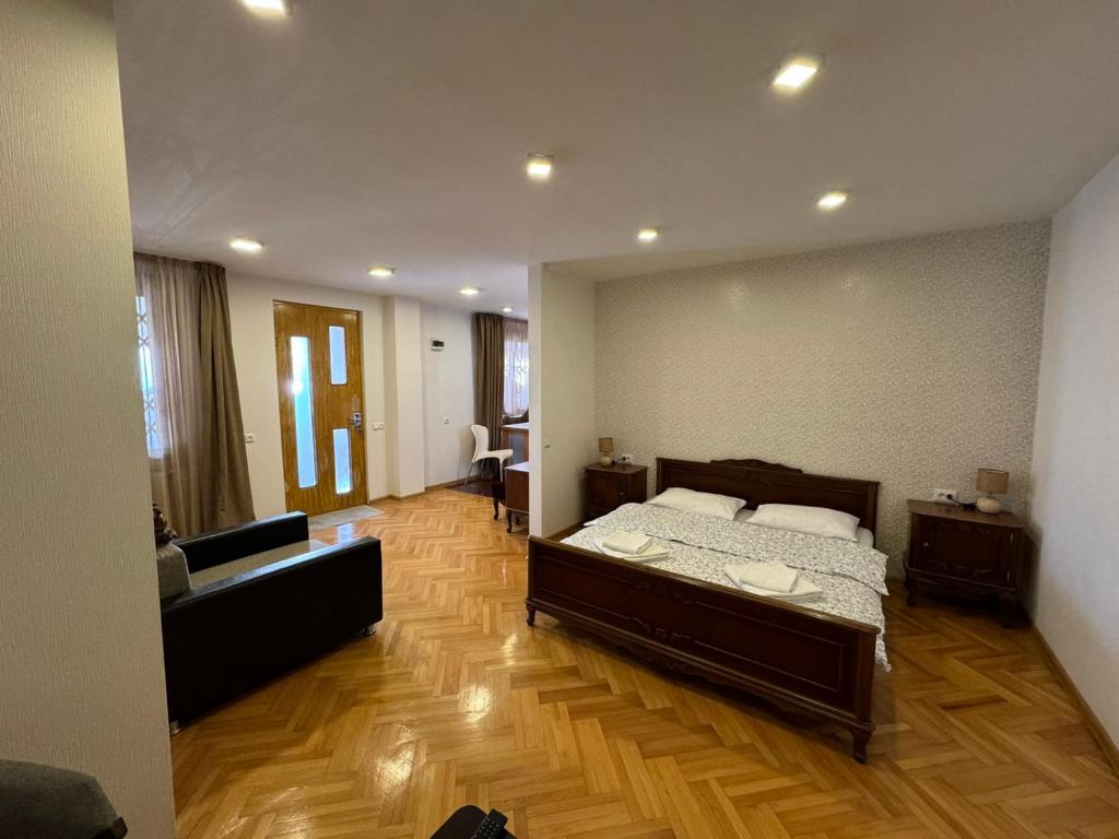 第比利斯K&N Guesthouse的一间卧室配有一张床和一张沙发