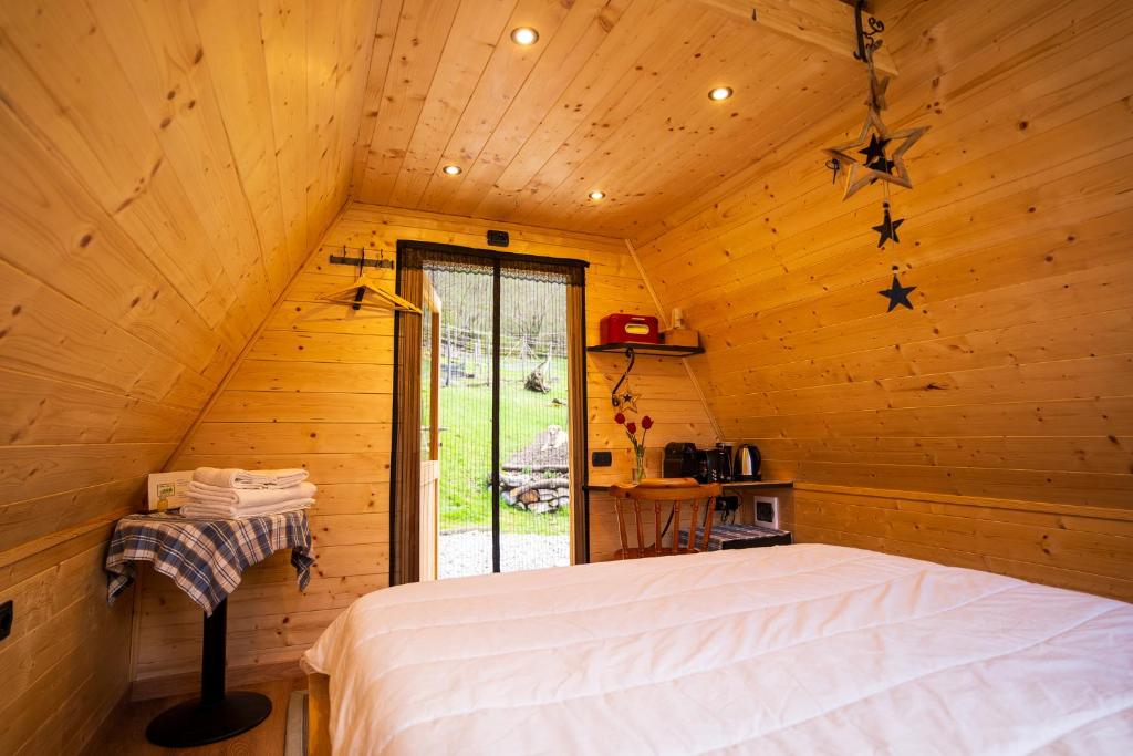 阿尔杰尼奥Baita Eleonora的小木屋内一间卧室,配有一张床
