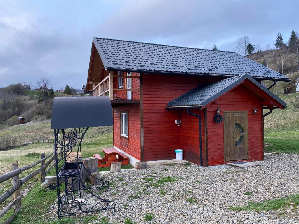 沃罗赫塔Шпінь 3的一间黑色屋顶的红色小房子
