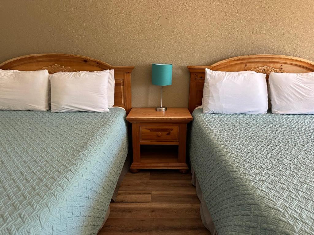 弗雷德里克斯堡落日套房汽车旅馆的两张睡床彼此相邻,位于一个房间里