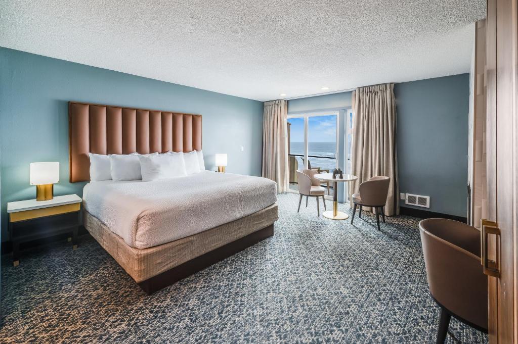 新港The Whaler的酒店客房带一张床、一张桌子和椅子