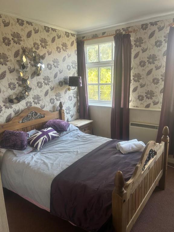 CrudgingtonTayleur arms的一间卧室设有一张床和一个窗口