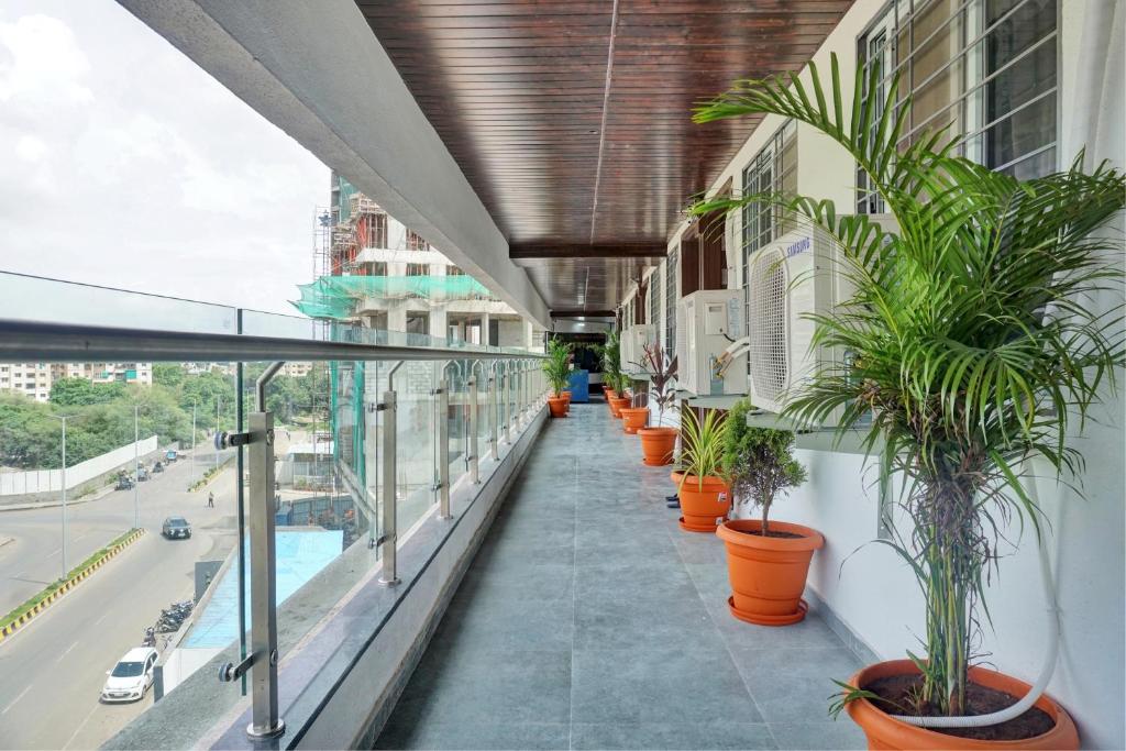 浦那OYO Collection O Hotel Rk Inn的建筑一侧种植盆栽植物的阳台