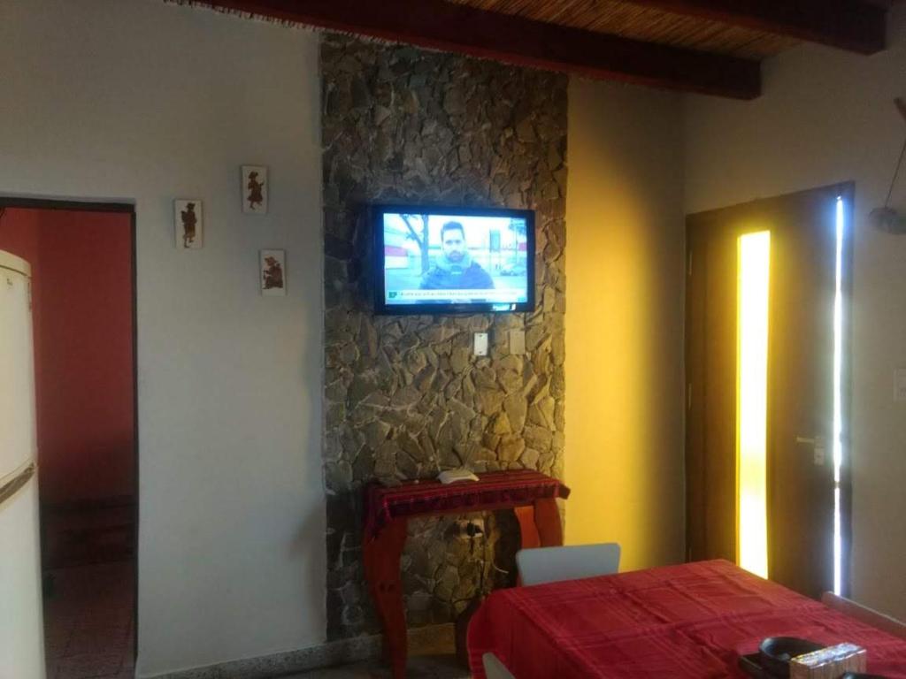 卡法亚特Casa Manipa -3 dormitorios的一间石墙上配有电视的房间