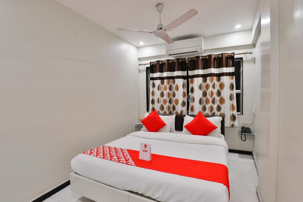 拉杰果德OYO Nova Hotel Nildeep的一间卧室配有两张带红色枕头的床