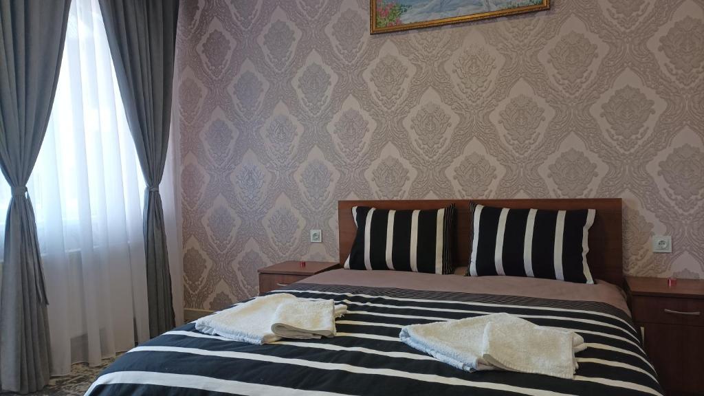 赫梅利尼茨基Готель Ассоль的一间卧室配有一张床,上面有两条毛巾