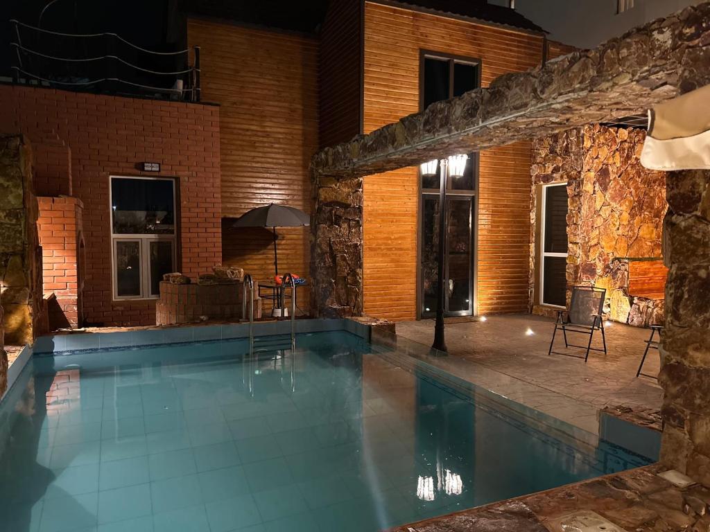 吉赞كوخ الشاطئ جمال الحاضر والطبيعة的一座石墙房子内的游泳池