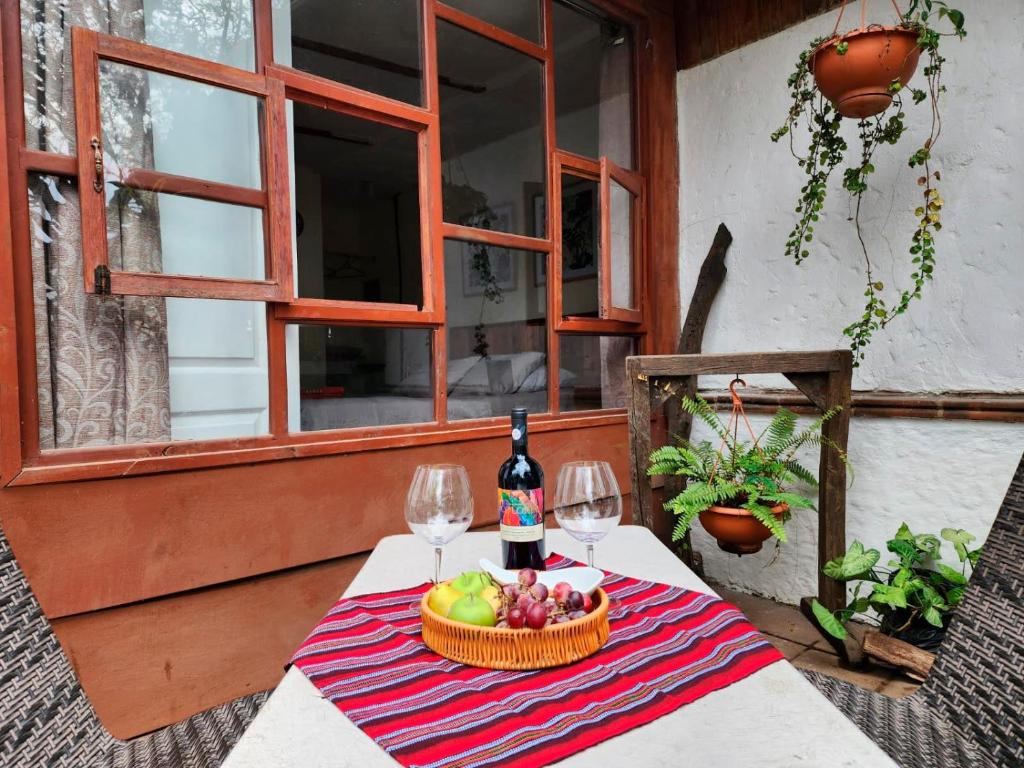 危地马拉CABAÑAS EN ZONA 16的一张桌子,上面放着一篮水果和一瓶葡萄酒