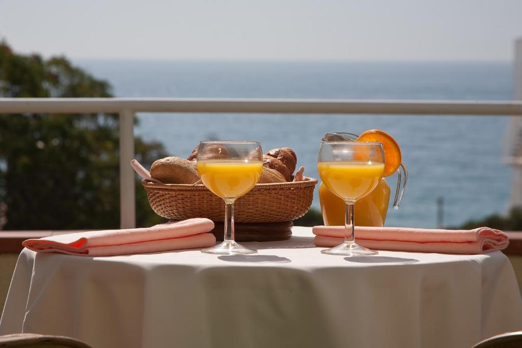 普拉加德阿罗克莱默尔酒店的一张桌子,上面放着两杯橙汁和一篮面包