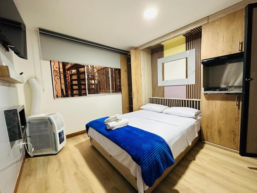 麦德林Hotel Lares 70 Laureles的一间卧室配有一张床和一台平面电视
