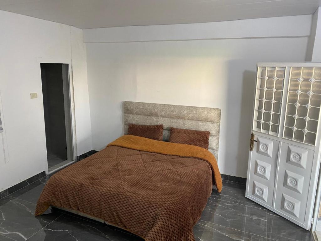 杰拉什huseein rooms的一间卧室配有一张带橙色毯子的床
