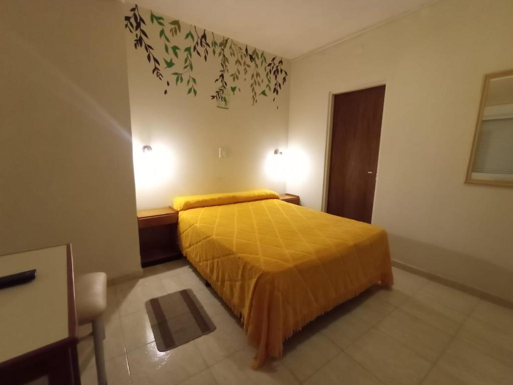 特尔马斯德里奥翁多HOTEL INTI YACU的卧室配有一张床,墙上有两盏灯