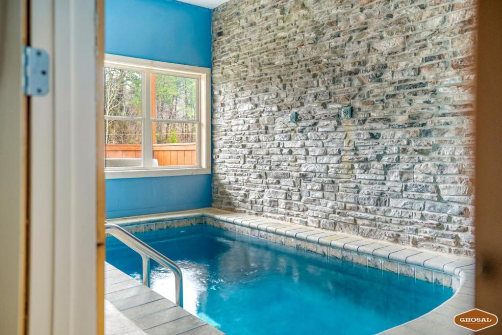 鸽子谷Rustic Mountain Retreat by Ghosal Luxury Lodging的砖墙房间的游泳池
